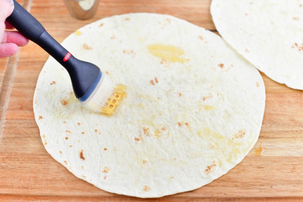 brushing a large tortilla with maple syrup