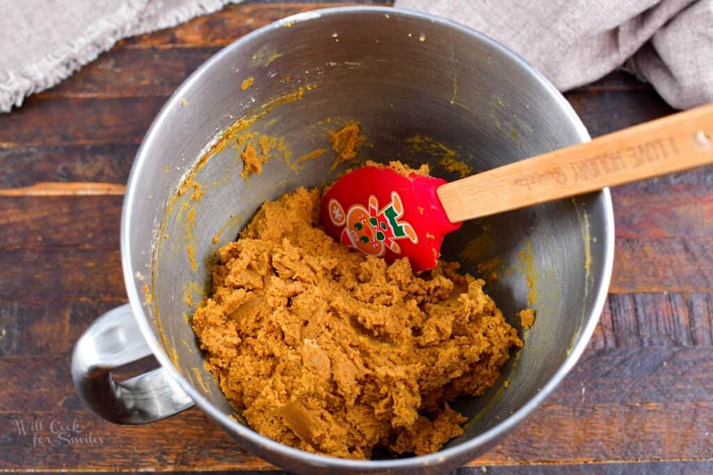 cookie dough in a mixing bowl with red spatula
