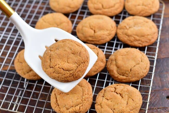 holding a cookie on the spatula next to the cooling rack