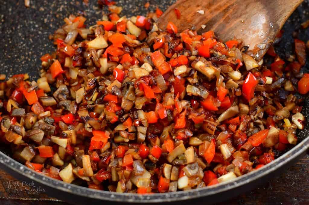 mushrooms, onions, and bell peppers sautéed in a pan