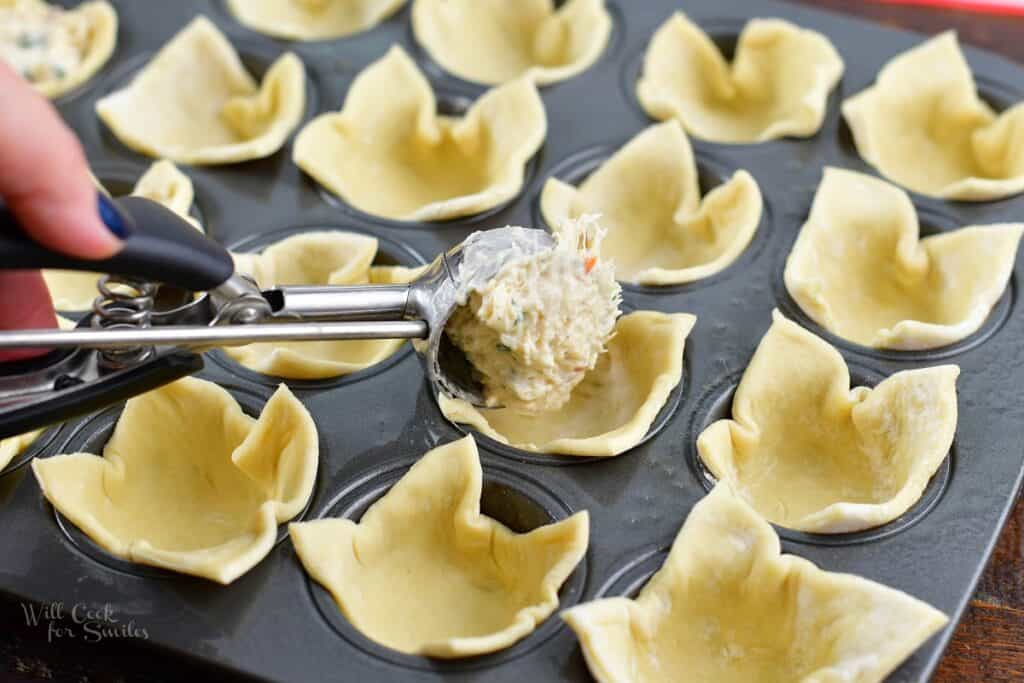 adding crab filling to the puff pastry cups