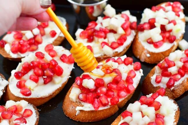 drizzling honey over pomegranate crostini