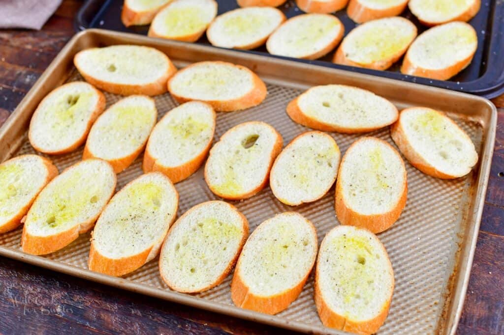 bread slices topped with oil, salt, and pepper on baking sheet