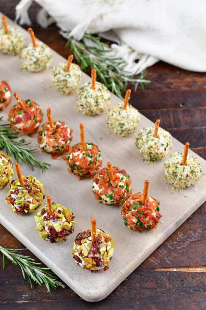 three rows of different mini cheese balls on the board