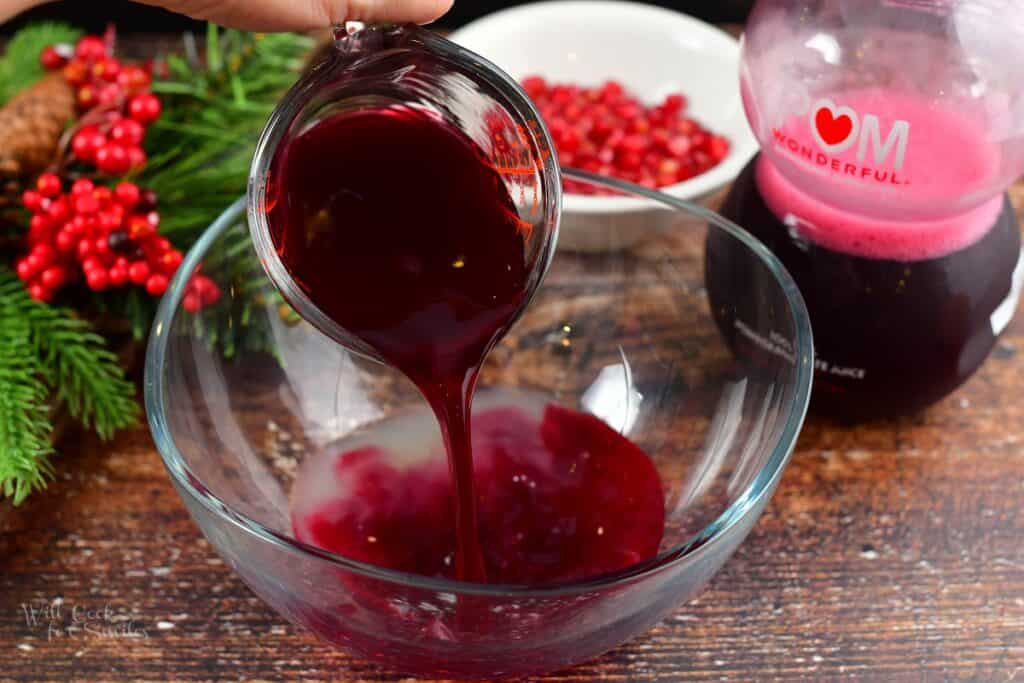 adding pomegranate juice to the punch bowl