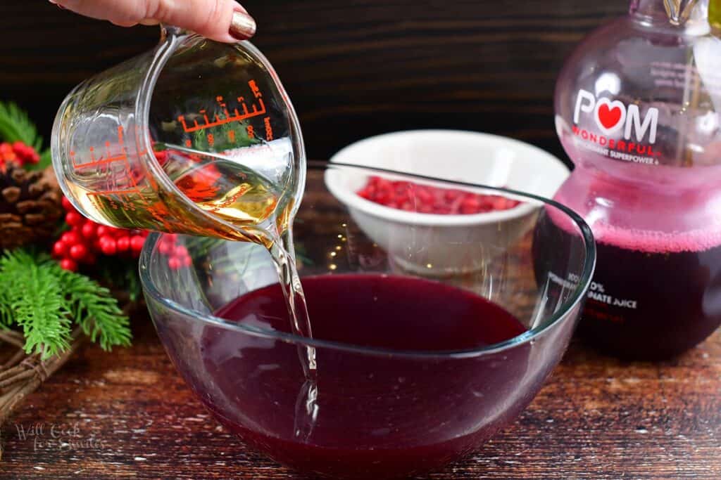 adding elderflower liqueur to the punch bowl