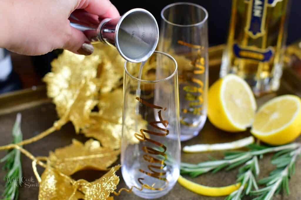 adding lemon juice to the empty champagne glass