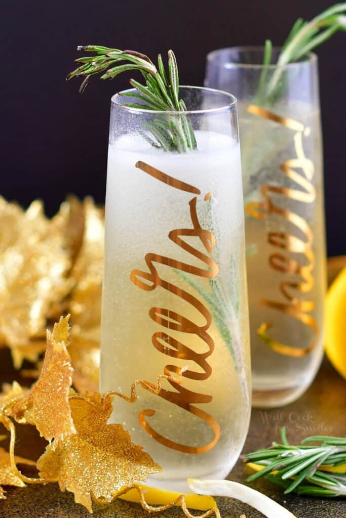 closeup of the tall glass with champagne cocktail and rosemary stick