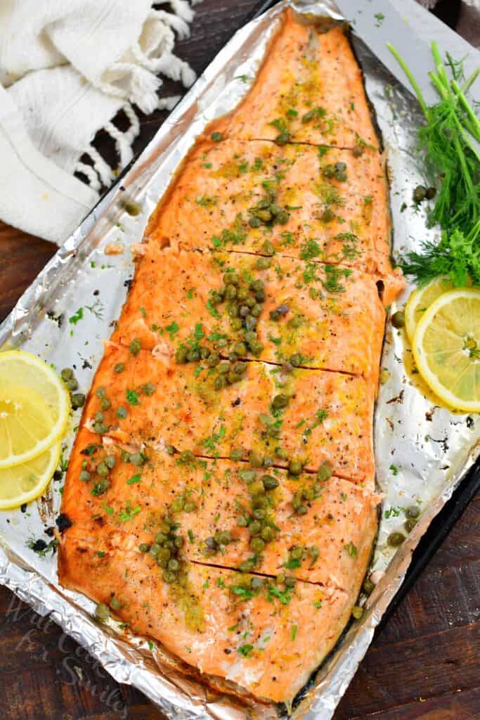 top view of whole baked salmon topped with capers sliced