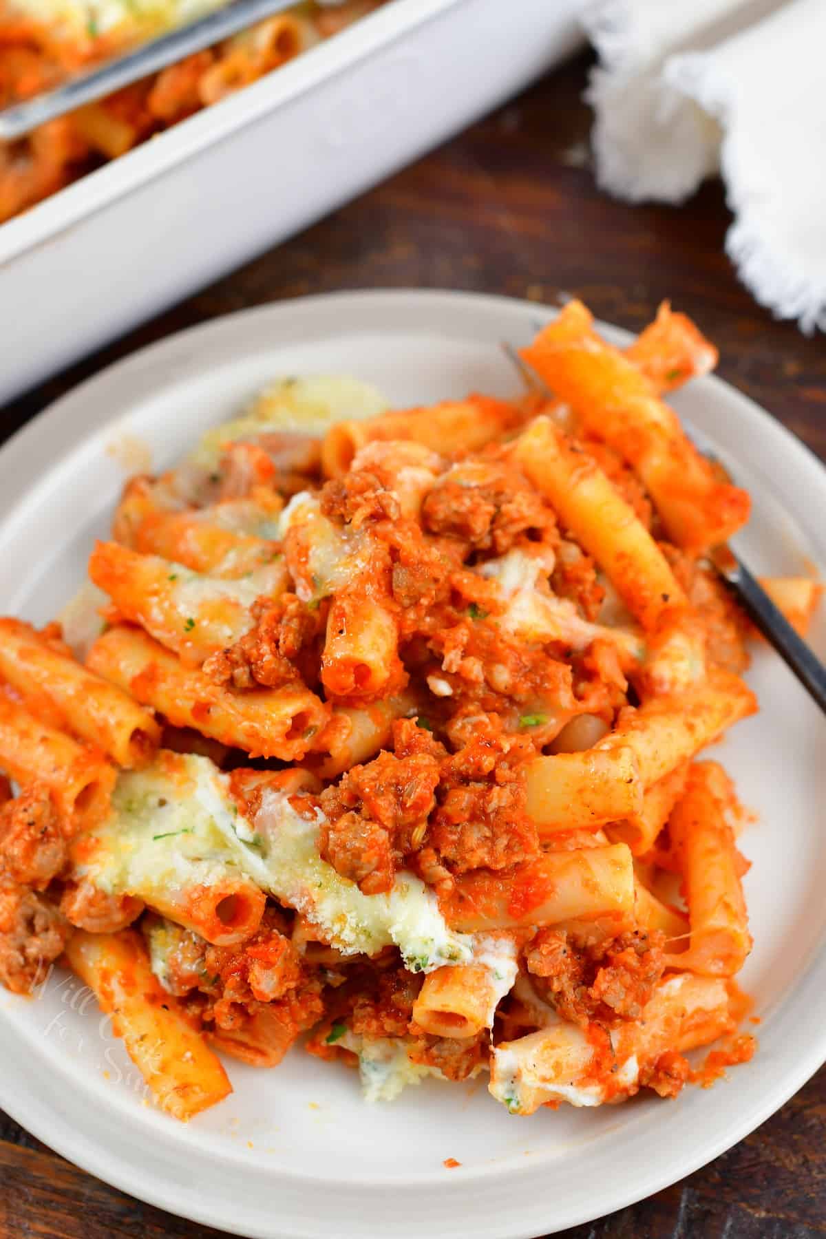 baked ziti with meat sauce in the plate with a fork