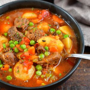 spooning some beef soup from a bowl