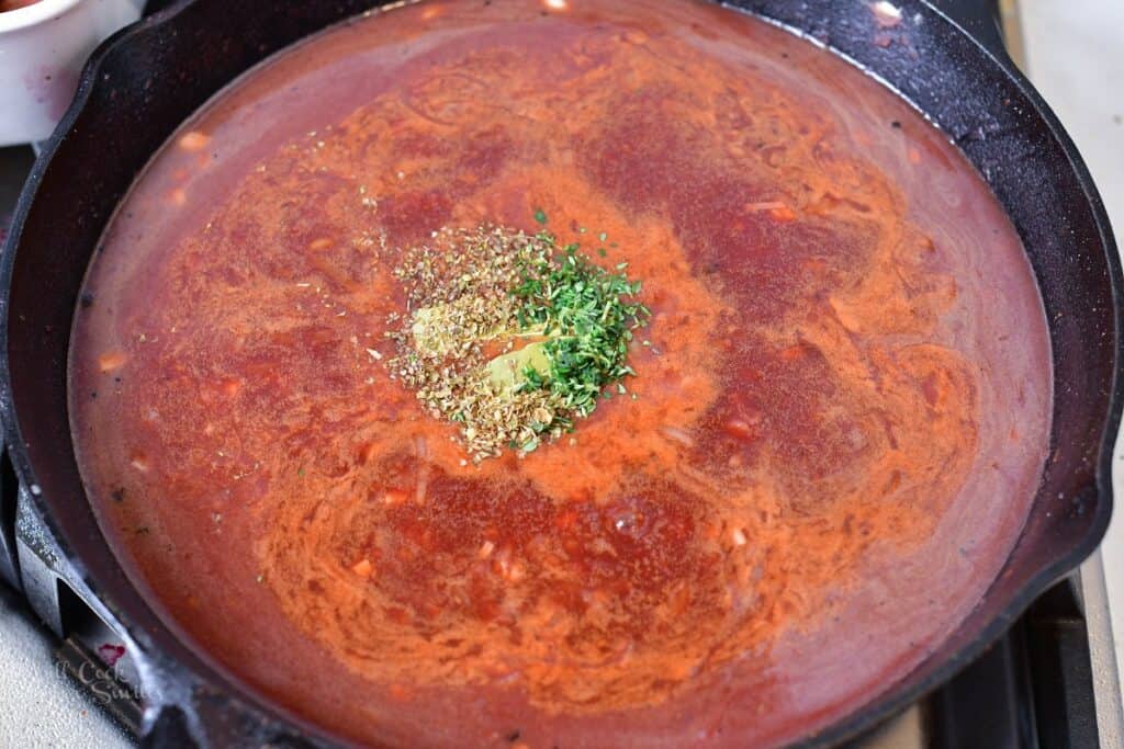 adding seasoning to the sauce in the skillet