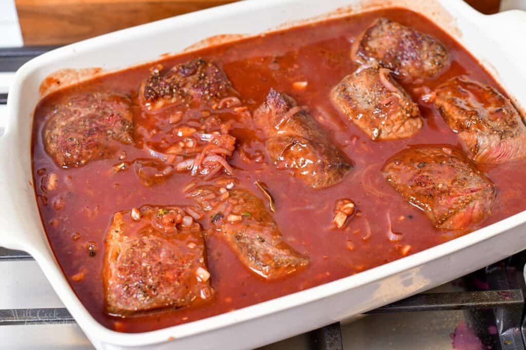 short ribs covered in sauce in a baking dish before baking