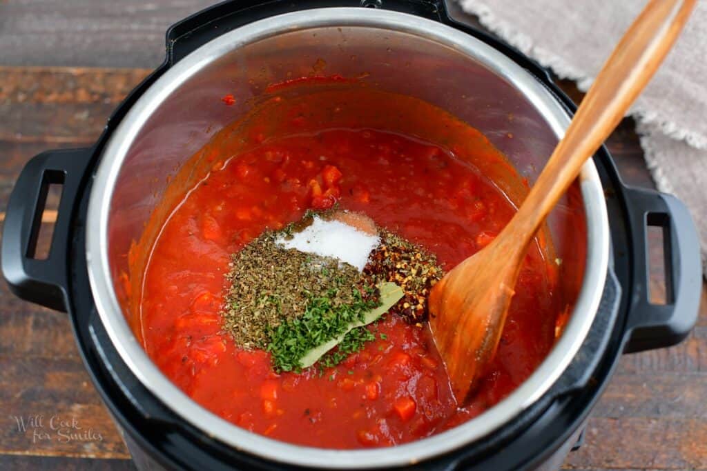 adding spices and seasoning to the sauce in the pot