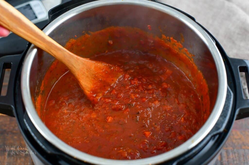 stirring cooked tomato sauce in the pot