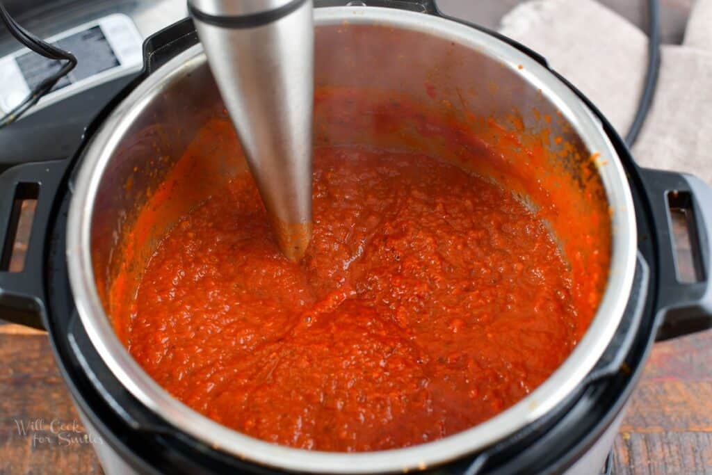 blending the pasta sauce with immersion blender