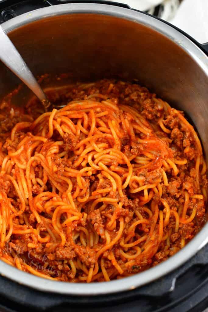 Scooping some pasta with sauce out of Instant Pot