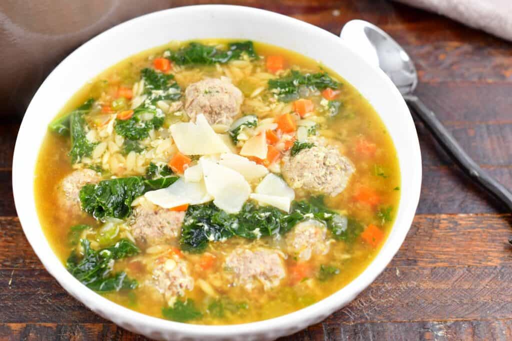 closeup of Italian wedding soup topped with shaved Parmesan