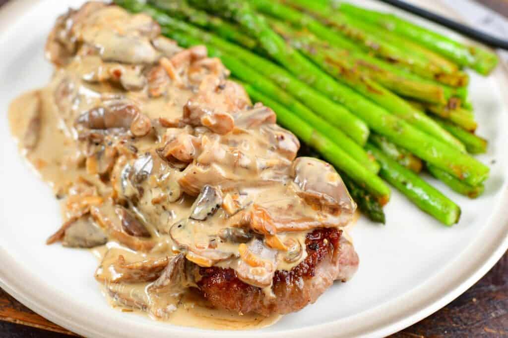 closeup of steak topped with creamy mushroom sauce