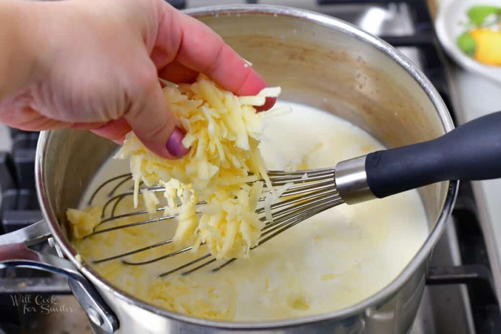 adding white cheddar cheese to the pot