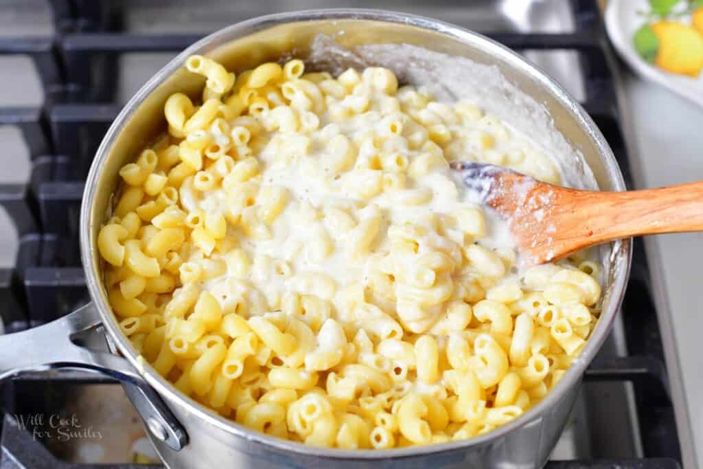 mixing macaroni with parmesan cheese sauce