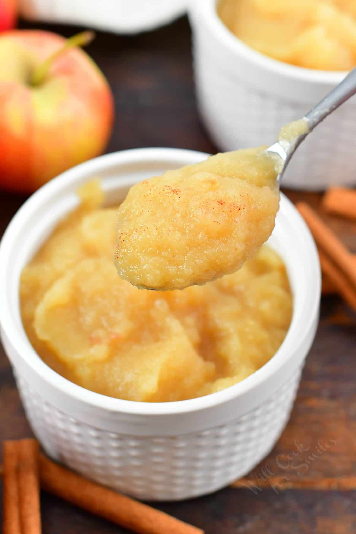 spooning out some applesauce from a cup