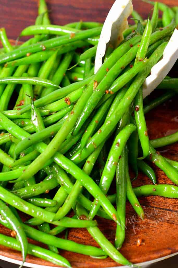 scooping up some haricots verts with tongs