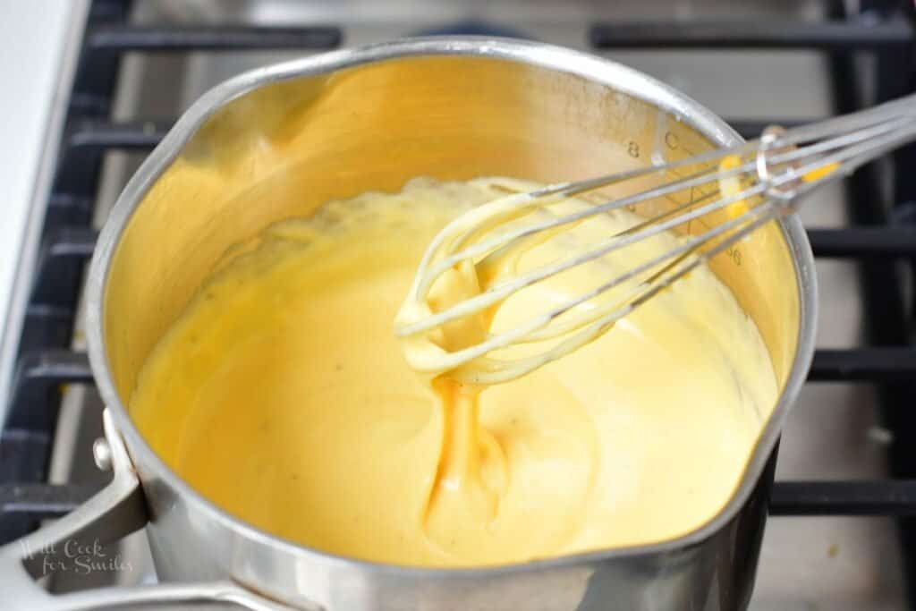 whisking nacho cheese in a sauce pot