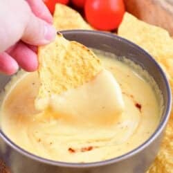 scooping some nacho cheese with a tortilla chip