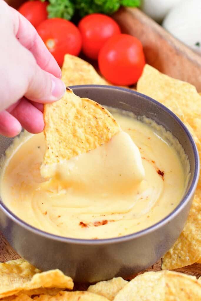 scooping some nacho cheese with a tortilla chip