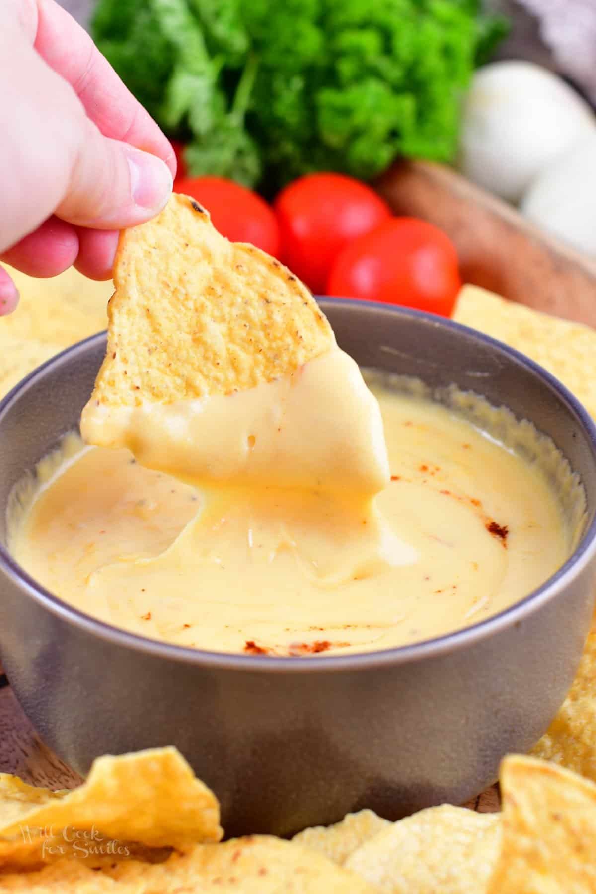 dipping tortilla chips dipped in a nacho dip