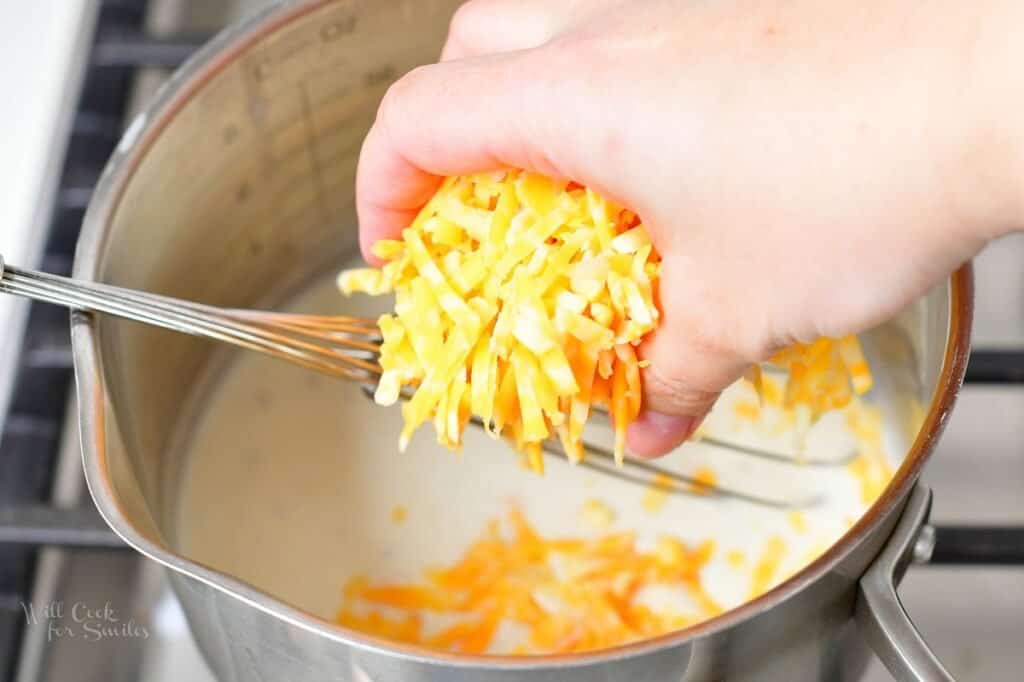 adding shredded cheese to the pot