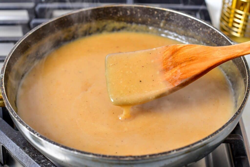 stirring gravy in a deep cooking pan