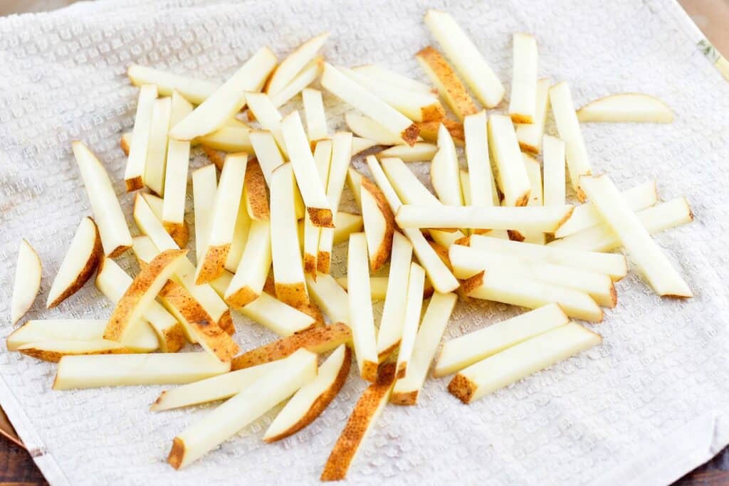 cut potatoes on a towel after soaking