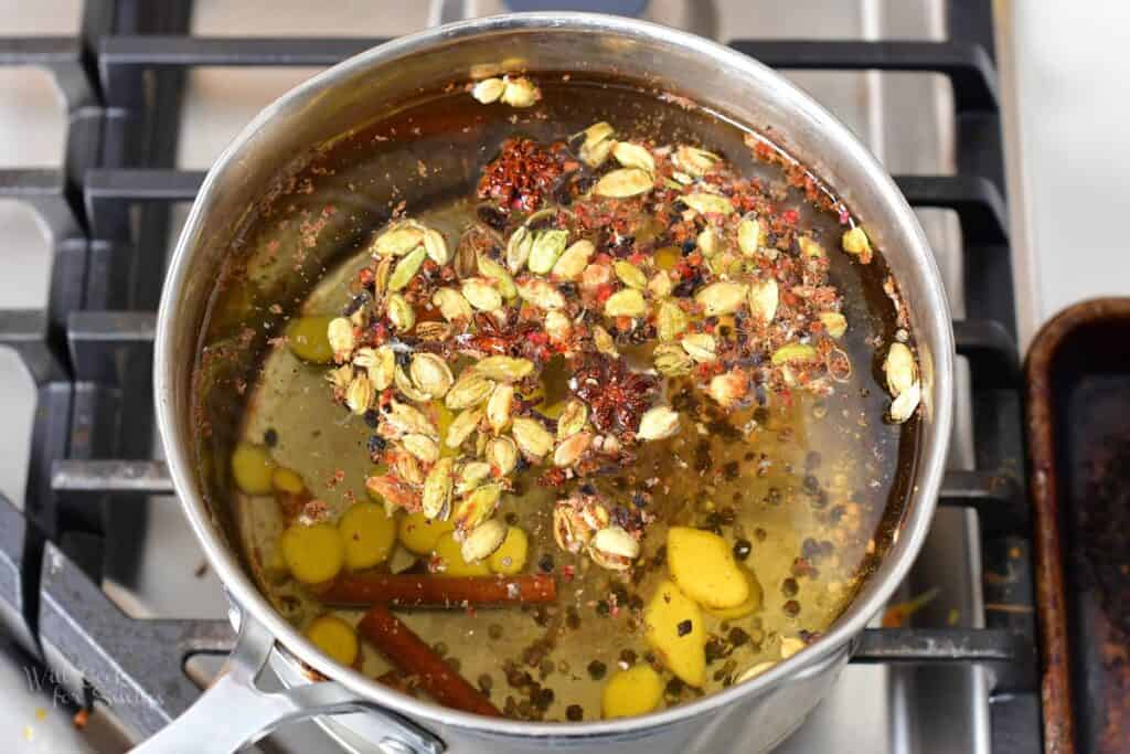 water in a pot with spices added for chai