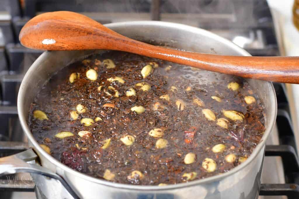 tea steeping with spices in a pot with a spoon