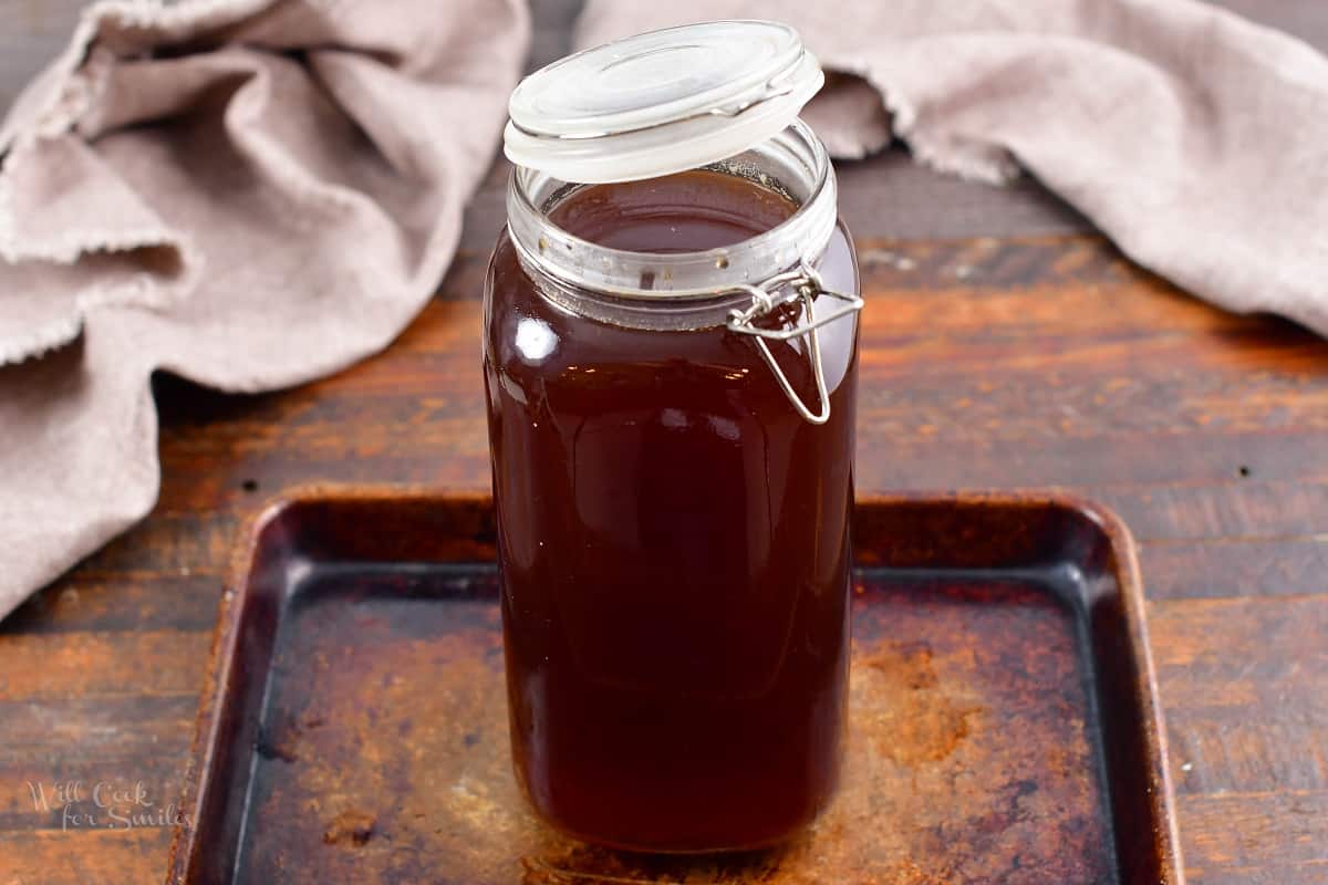 chai concentrate in a large glass storage jar on a baking sheet.
