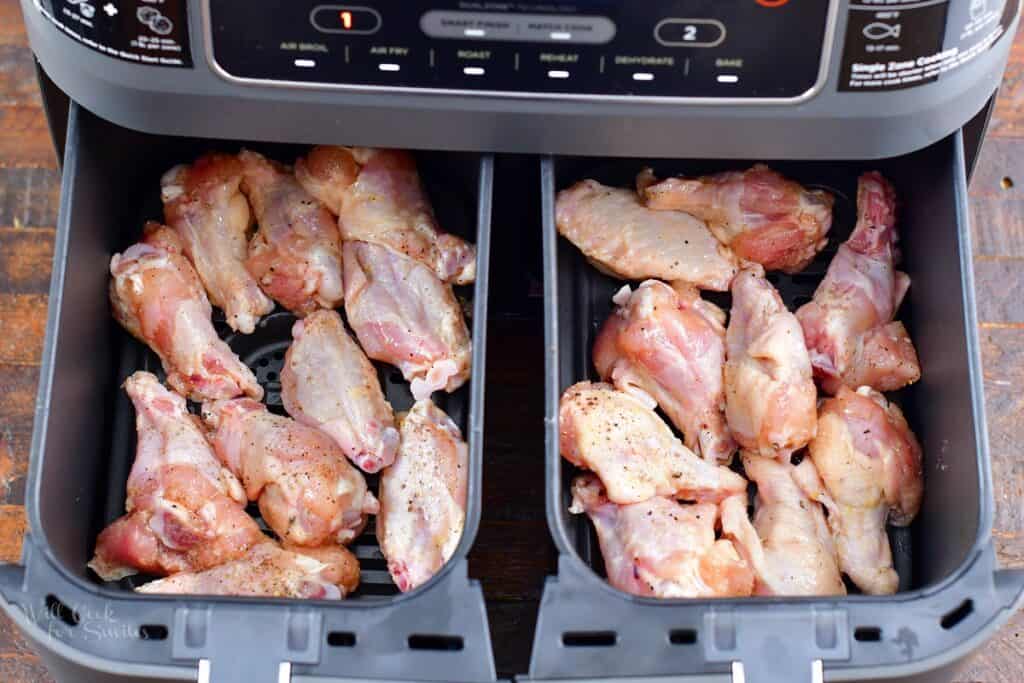 uncooked chicken wings in air fryer baskets