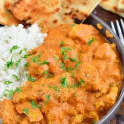 closeup of butter chicken over rice in a bowl