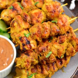 skewers of chicken satay layered on a plate