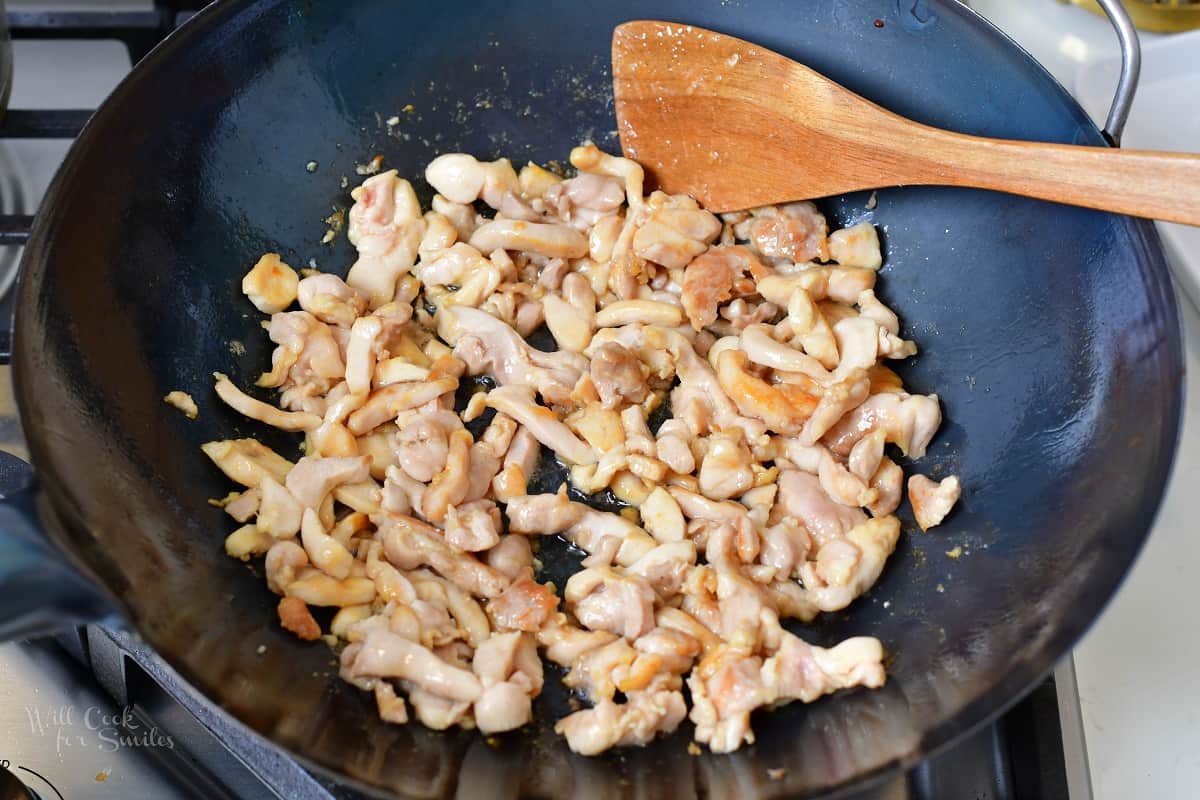 searing chicken in a wok