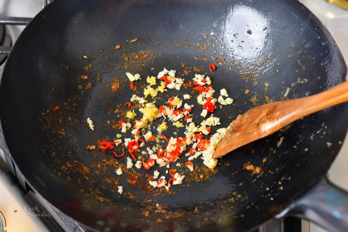 searing chilis ginger and garlic in a wok