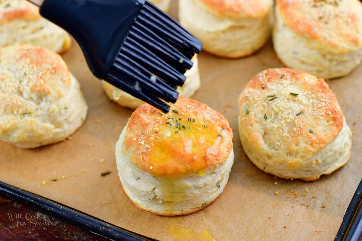 brushing biscuits with melted garlic butter