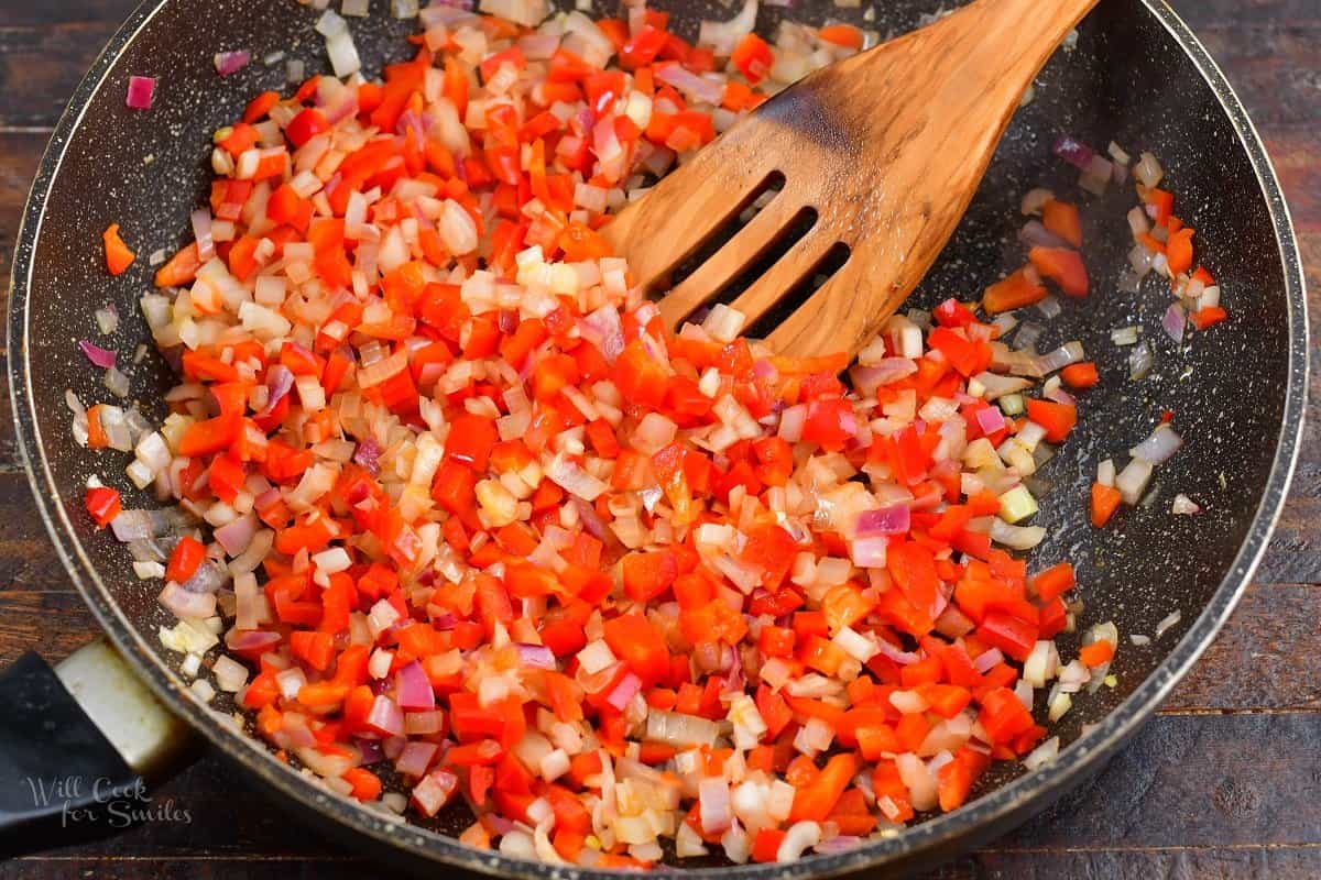 sautéing onions and peppers in a pan