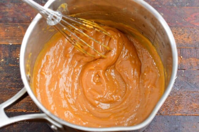 whisking the sauce in a sauce pot