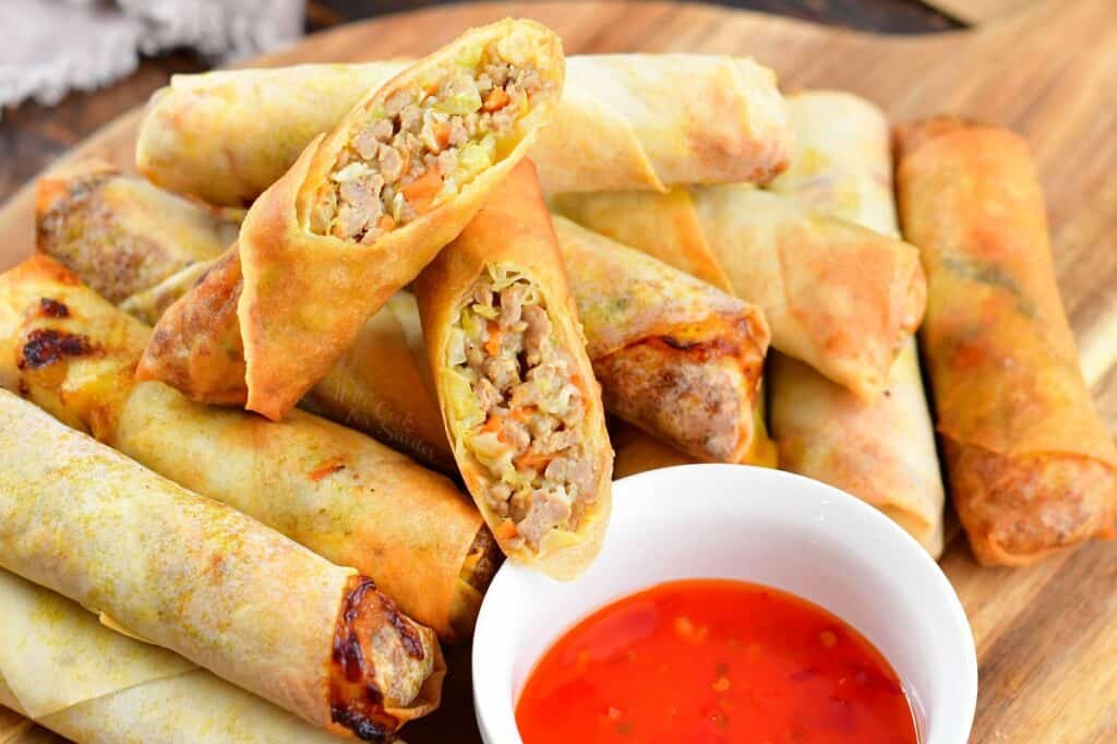 top view of layered spring rolls on the cutting board with one cut in half