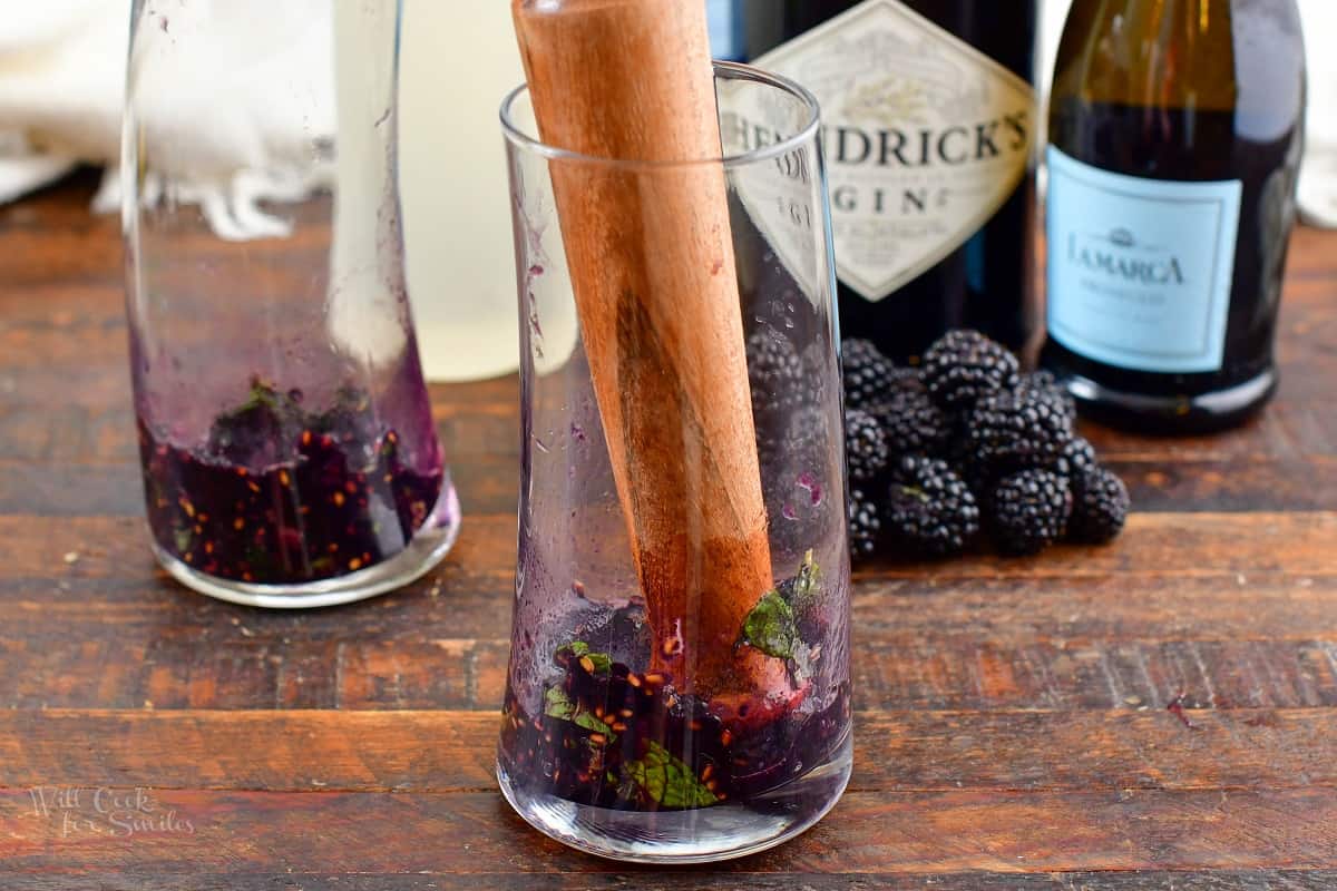mashing blackberries and mint in a glass