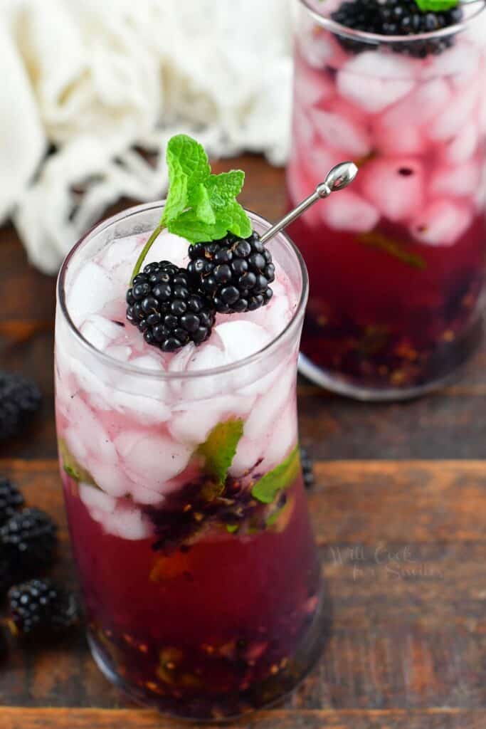top view of blackberry cocktail in a glass with blackberries and mint