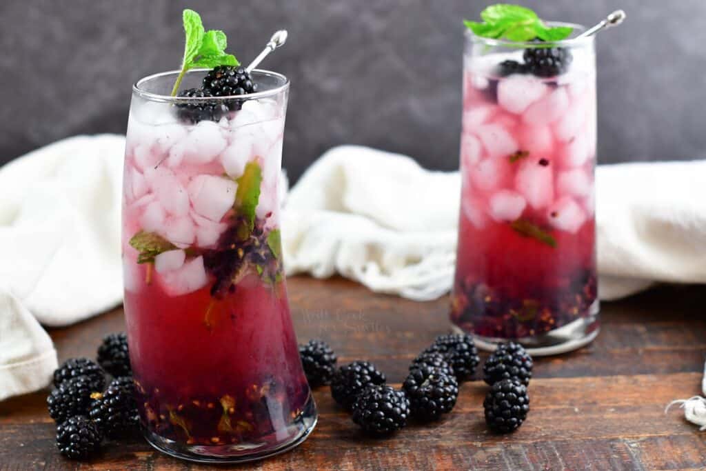 side view of two blackberry cocktails with blackberries