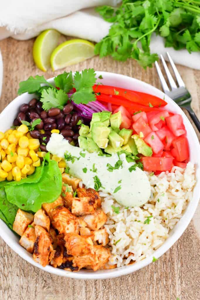 top view of the burrito bowl with limes and cilantro near